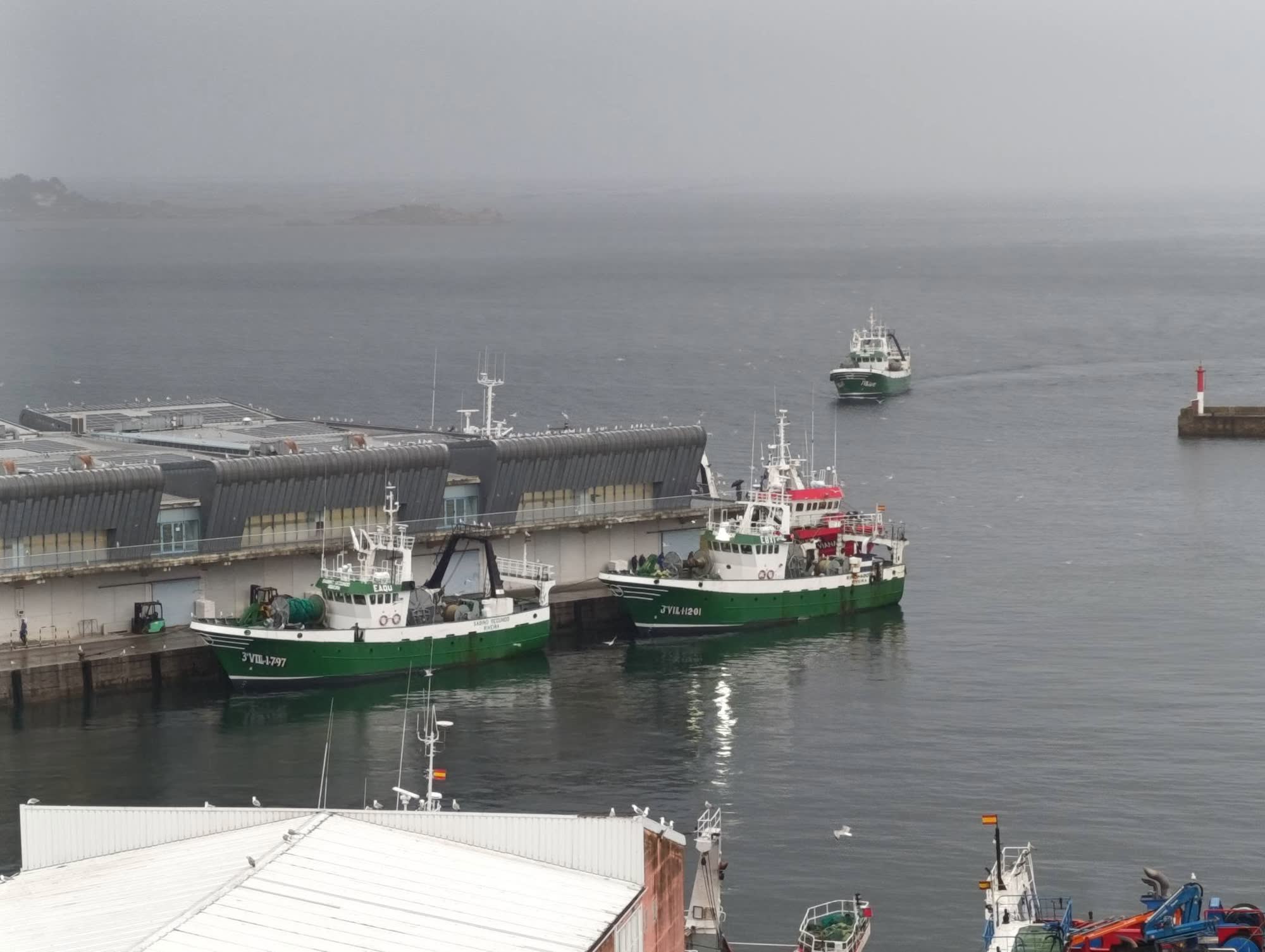 Arrastreiros amarrados no peirao de Ribeira entre a néboa