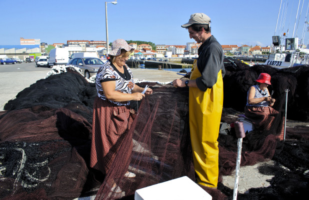 Atadoras reparando as redes na explanada do peirao de Aguiño