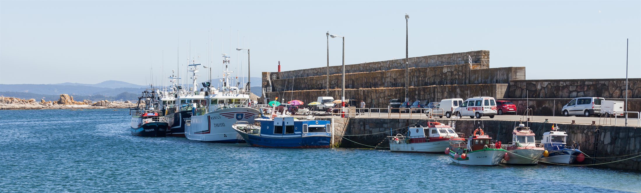 Flota pesqueira amarrada no peirao de granito do porto de Aguiño